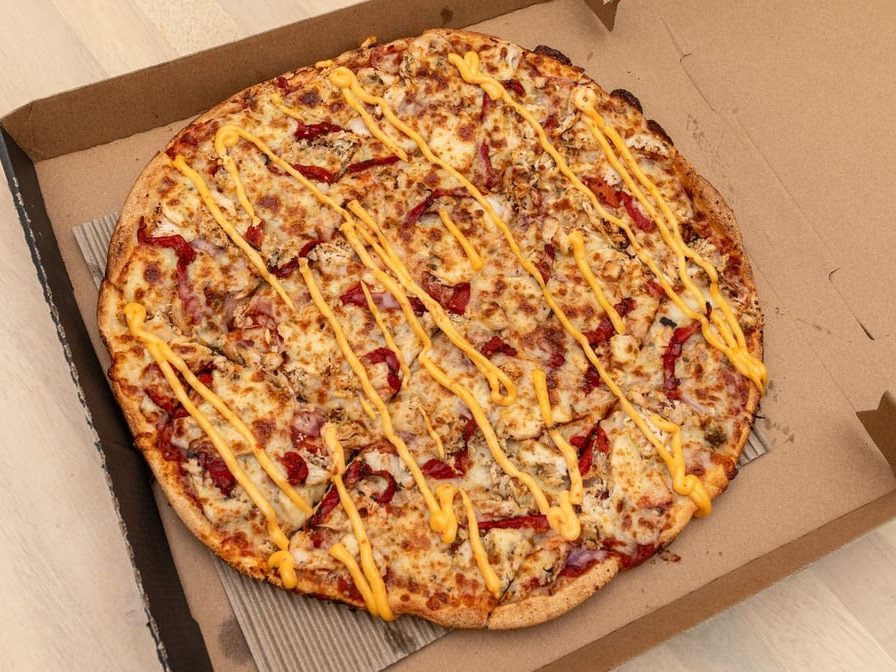 Chicken pizza with cheese drizzle, fresh in the box