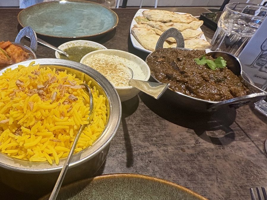 Table spread: saffron rice, raita, spinach curry and naan